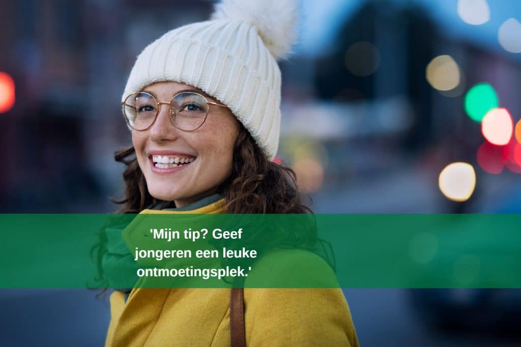 Jonge vrouw met bril en witte wollen muts zegt: "Mijn tip? Geef jongeren een leuke ontmoetingsplek".